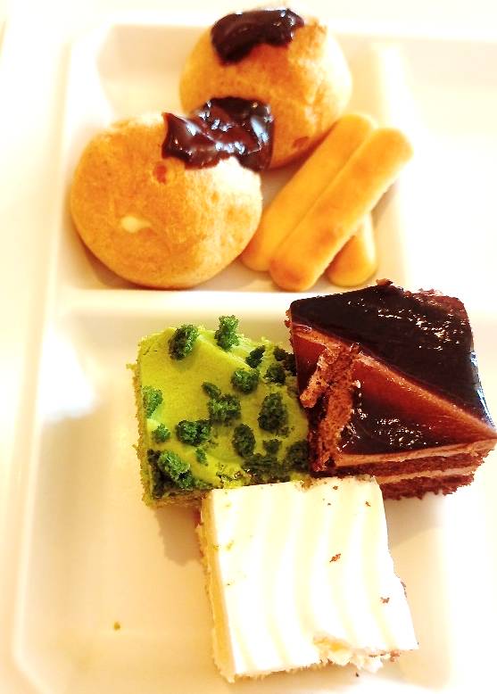Mini cakes in green tea, chocolate and vanilla. Assorted cream puffs and cookies.